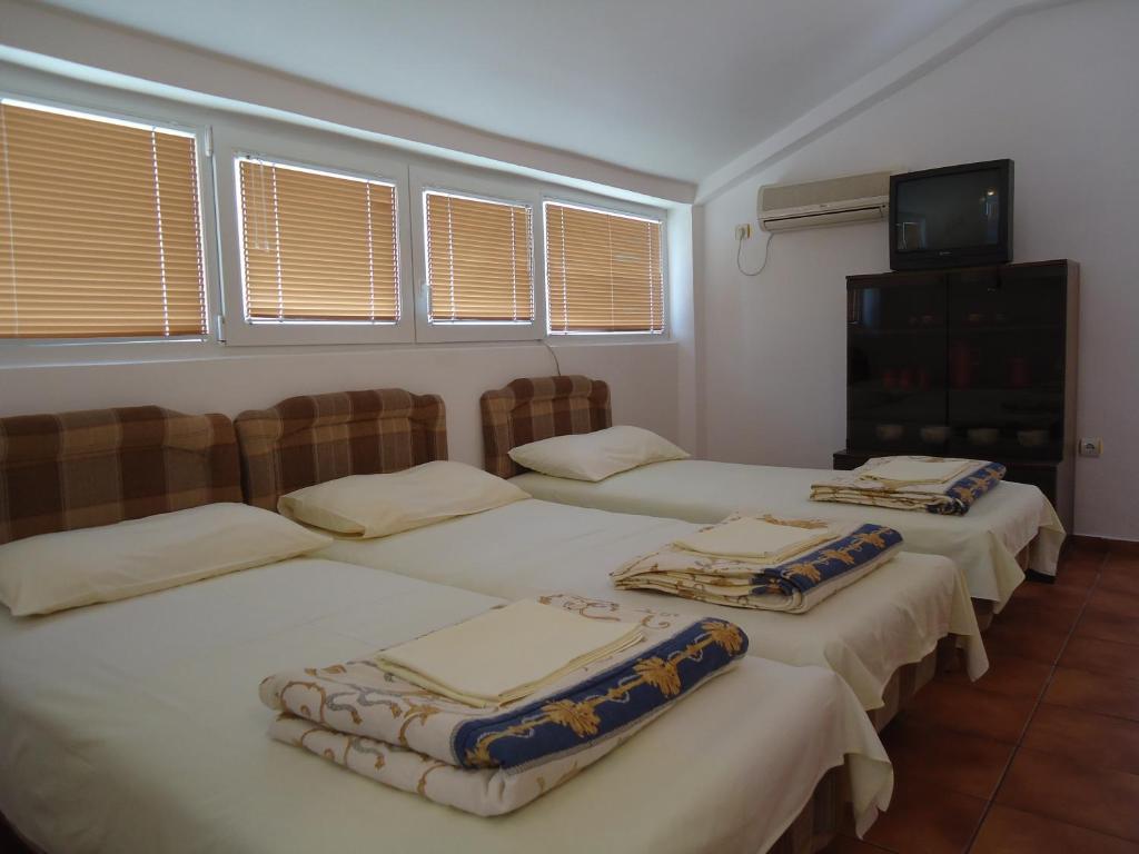 um grupo de três camas num quarto com janelas em Nada Jablan's Studios em Herceg Novi