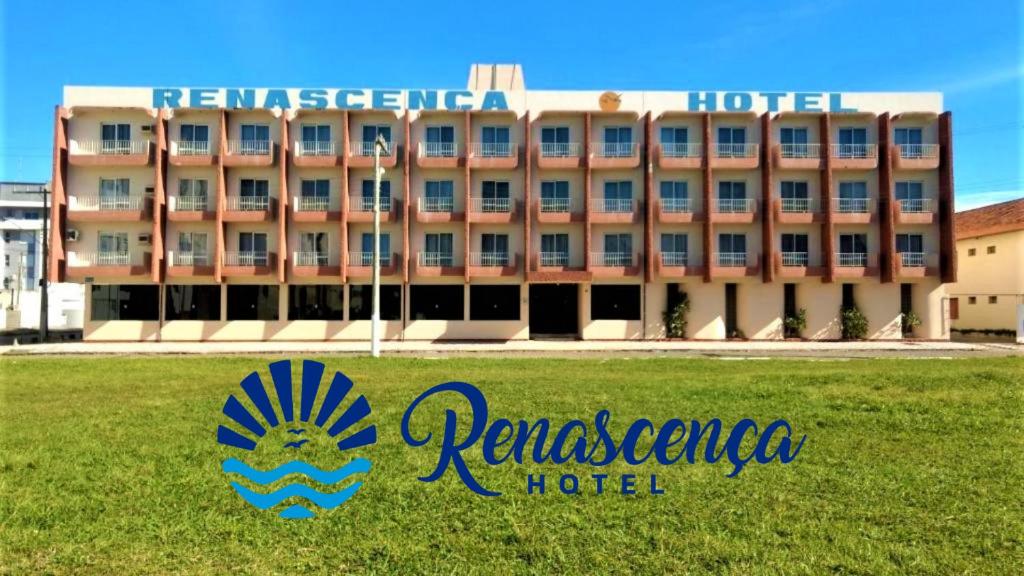 a hotel with a sign in front of a building at Atlântico Sul Renascença Hotel in Laguna