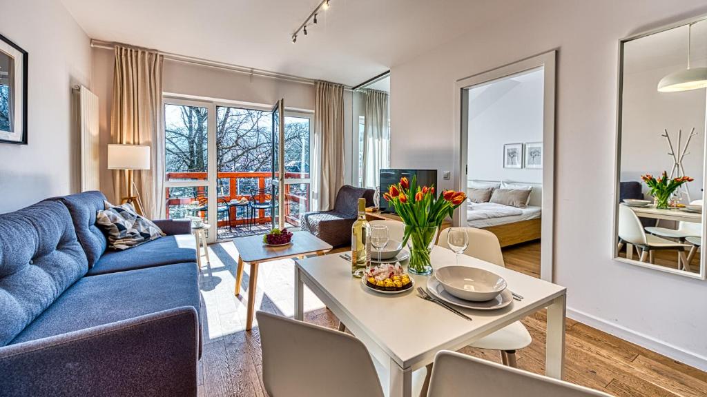 ein Wohnzimmer mit einem blauen Sofa und einem Tisch in der Unterkunft Apartament Skandynawski 54 - 5D Apartments in Świeradów-Zdrój