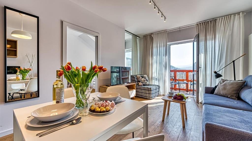 ein Wohnzimmer mit einem Tisch und einem blauen Sofa in der Unterkunft Apartament 57 Holiday Mountain Residence - 5D Apartamenty in Świeradów-Zdrój