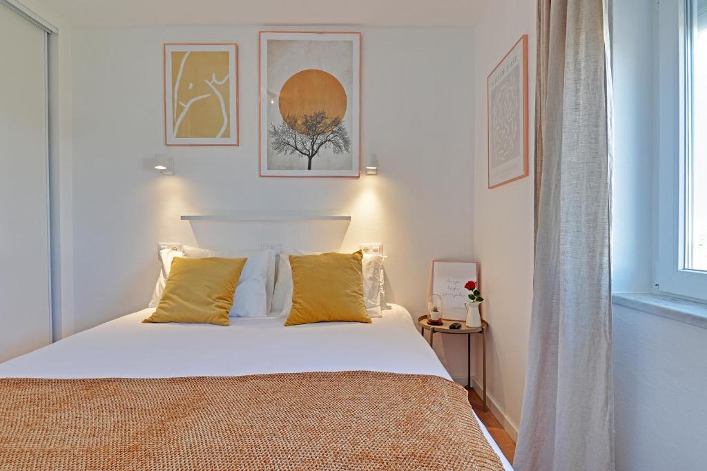 a bedroom with a white bed with yellow pillows at SEA SALT SAGRES APARTMENT in Sagres