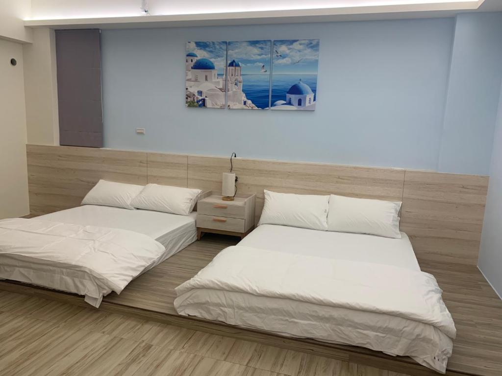 twee bedden naast elkaar in een kamer bij 僑居民宿 in Magong