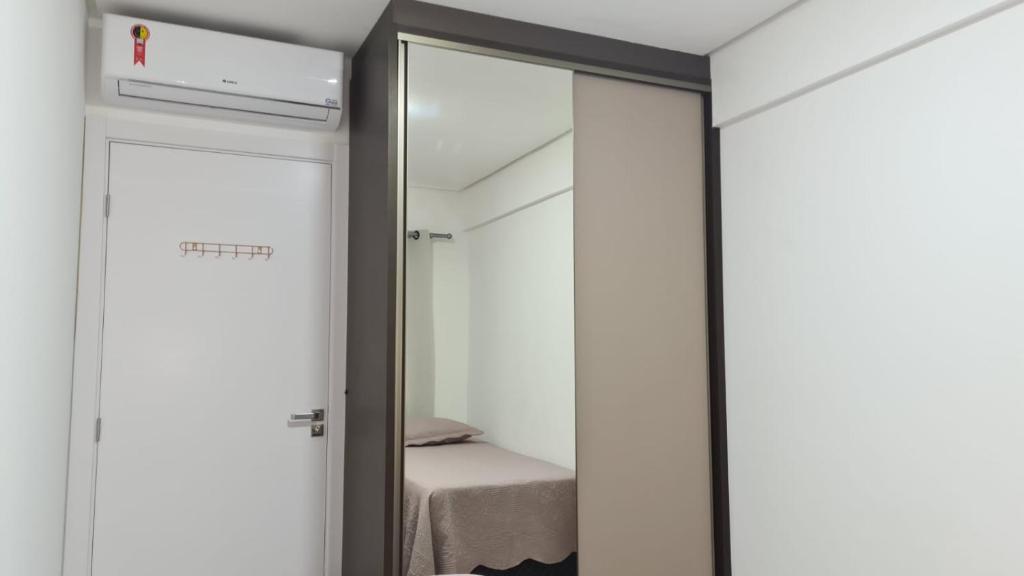 a bedroom with a mirror and a bed in a room at Apartamento encantador na praia de Navegantes in Navegantes
