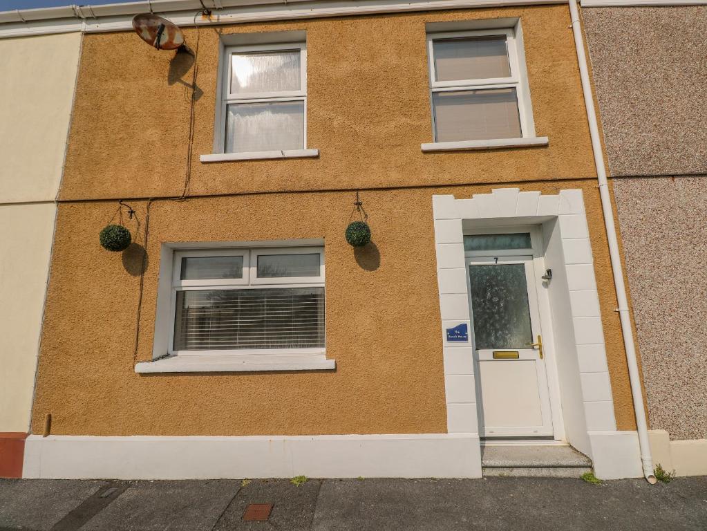 a brick house with two windows and a door at The Beach House in Llanelli