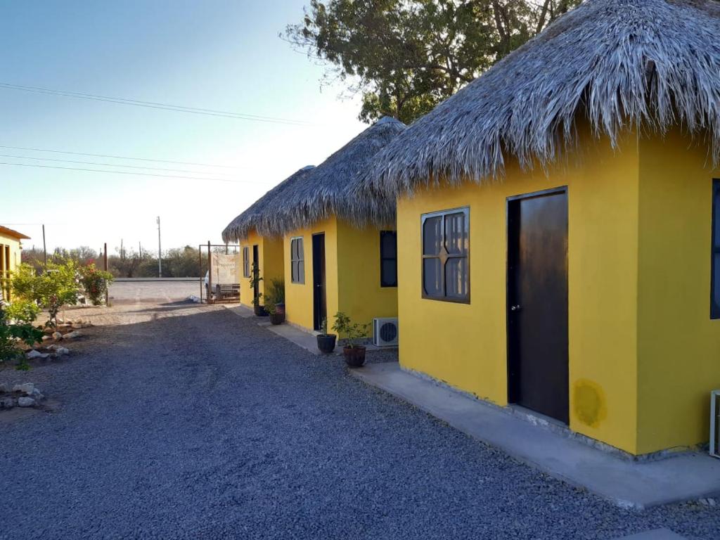 un edificio giallo con tetto di paglia di La Regional a Loreto