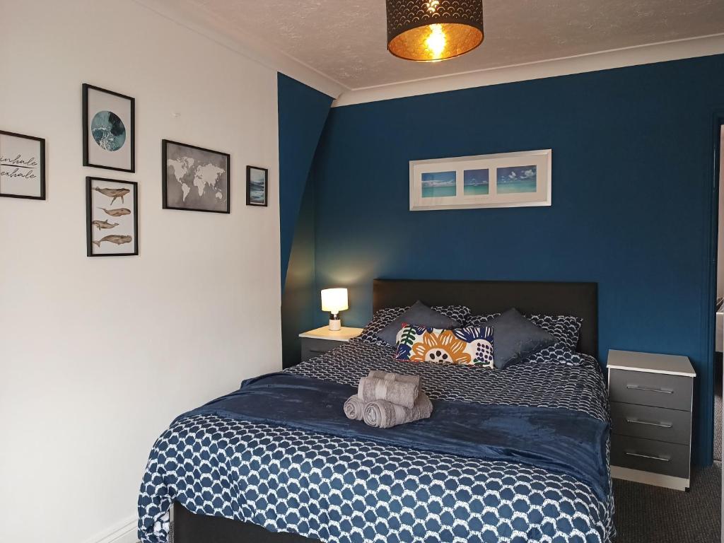a blue bedroom with a bed with a blue wall at Sunny Beach top apartment 4 in Skegness