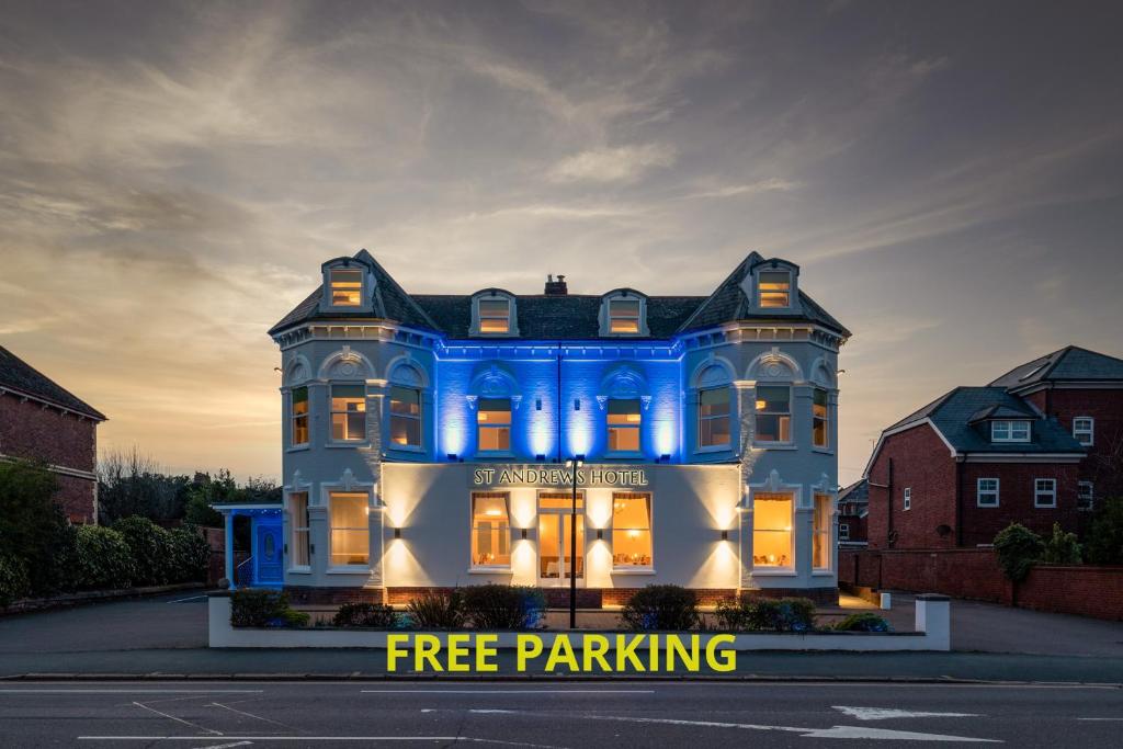 a large blue house with its lights on at St Andrews Hotel in Exeter