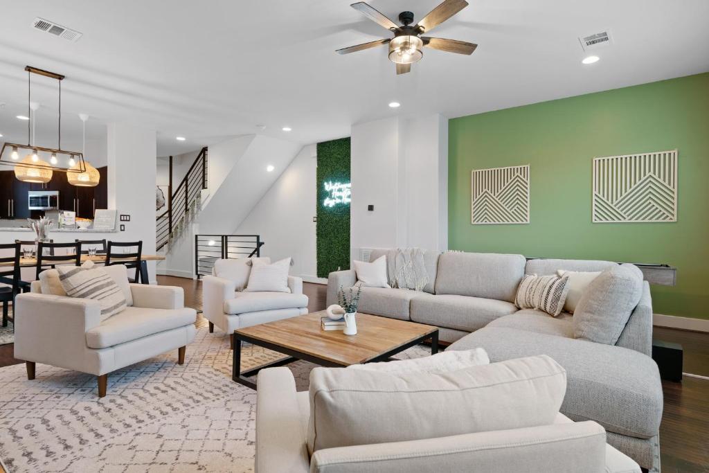 una sala de estar con muebles blancos y una pared verde. en Central Luxury with Deck, Fire Pit, BBQ, Walkscore of 90, en Houston