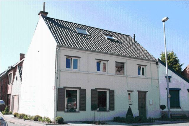 a white house with a dog looking out of the window at Sino in Dendermonde