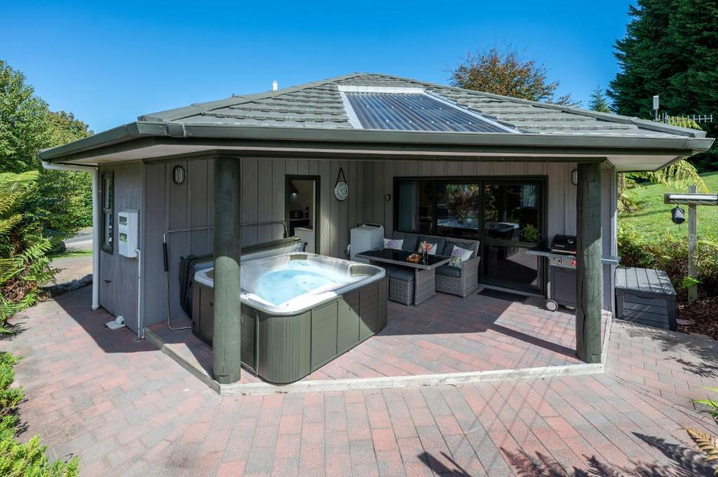 陶波的住宿－Acacia Heights - Garden Cottage - Taupo，露台的凉亭设有热水浴池