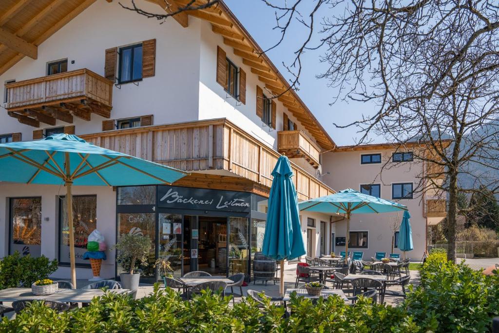 un bâtiment avec des tables et des parasols devant lui dans l'établissement Haus Margreiter, à Nußdorf am Inn