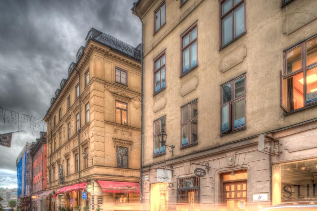 uma pintura de dois edifícios altos em uma rua da cidade em Archipelago Hostel Old Town em Estocolmo