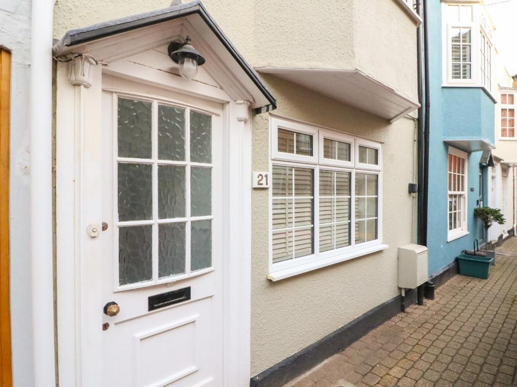 een witte deur en ramen op een huis bij Anchor Cottage in Weymouth