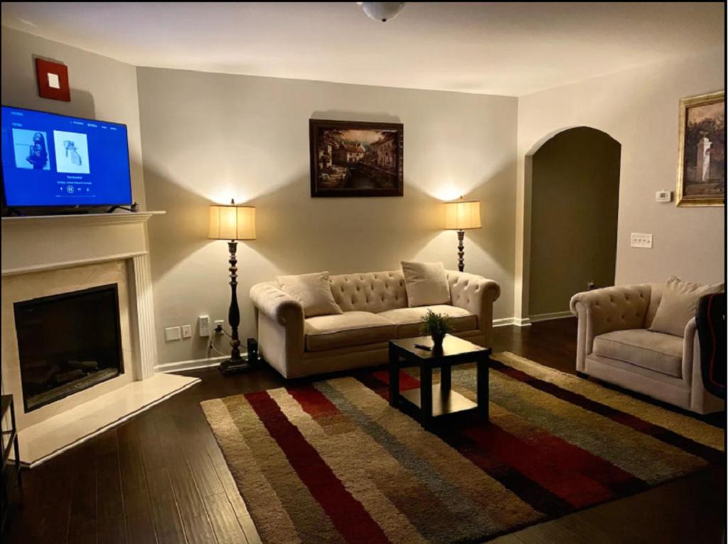 a living room with two couches and a flat screen tv at Charles Emihe in Newnan
