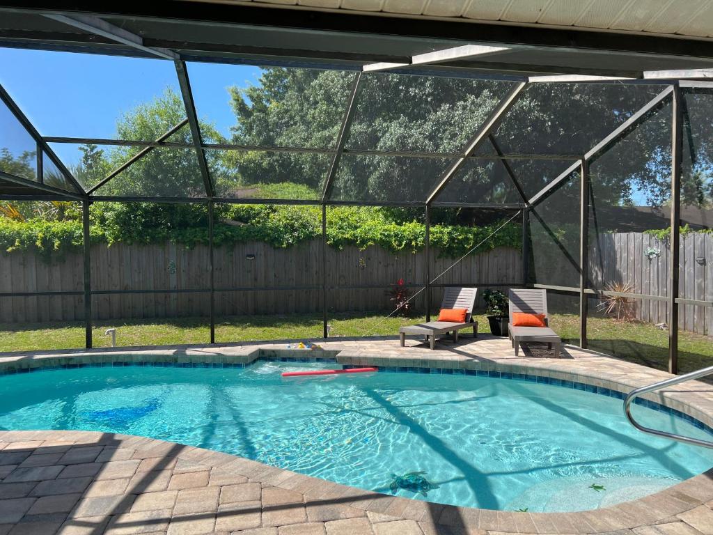 een zwembad in een achtertuin met een grote glazen wand bij 3 bedrooms house with private, heated pool 8 miles to Siesta Key Beach, in Sarasota