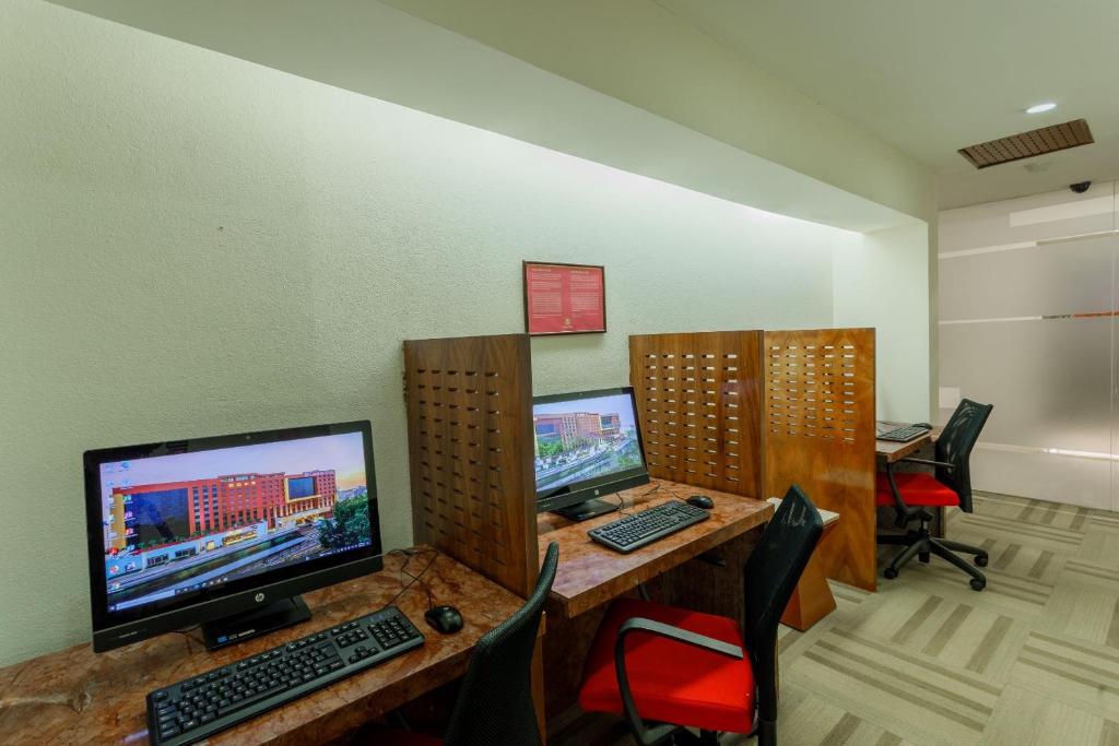 a room with three computer monitors on a desk at Camino Real Aeropuerto in Mexico City