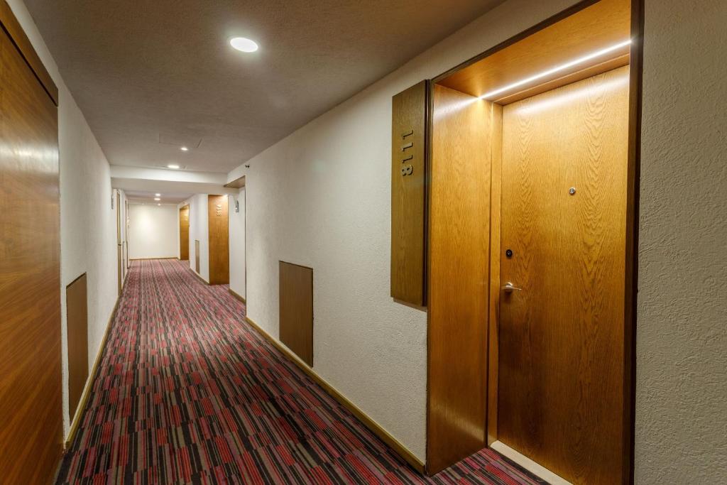 a corridor of a hotel room with a hallway with a door at Camino Real Aeropuerto in Mexico City