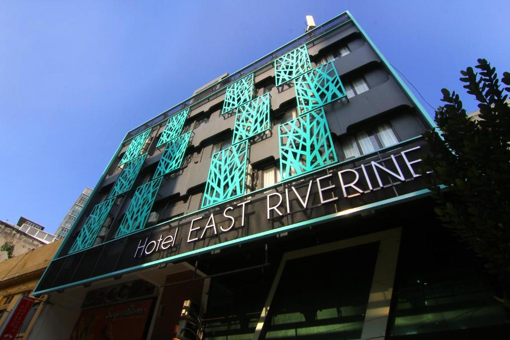 East Riverine Boutique Hotel في كوالالمبور: مبنى عليه لافته تقول فندق شرق النهر