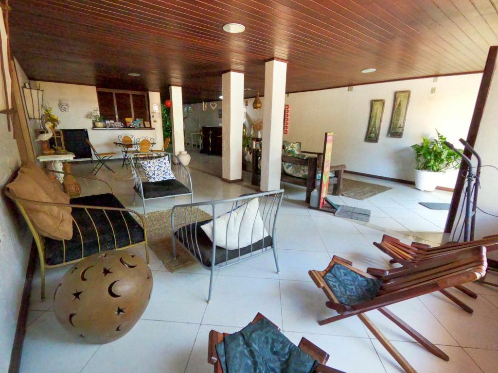 a large living room with chairs and a table at Pousada Praiana Pipa in Pipa