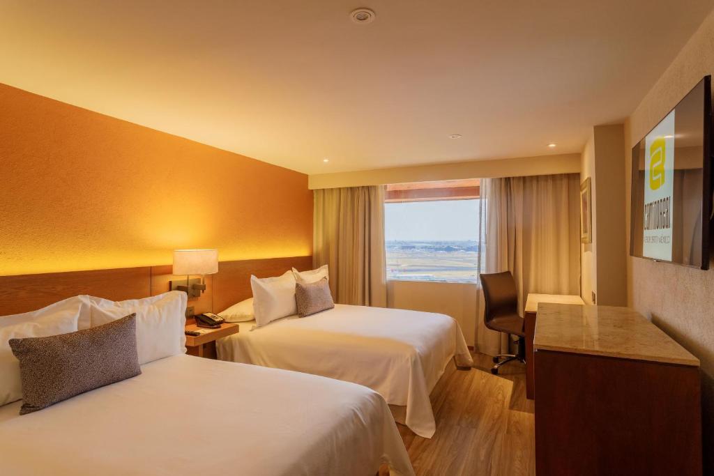 a hotel room with two beds and a window at Camino Real Aeropuerto in Mexico City