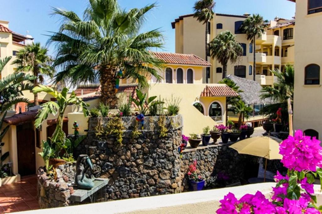 Blick auf ein Gebäude mit Palmen und Blumen in der Unterkunft Vista Hermosa Resort and Spa in Rosarito
