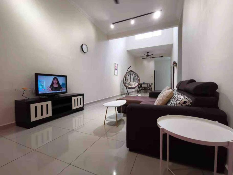 - un salon avec un canapé et une télévision dans l'établissement M Guest House, à Muar