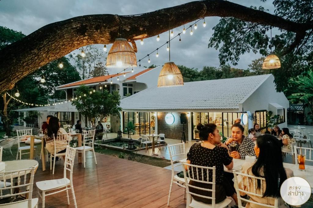 a group of people sitting at tables at a restaurant at Tree Tara hotel in Lampang