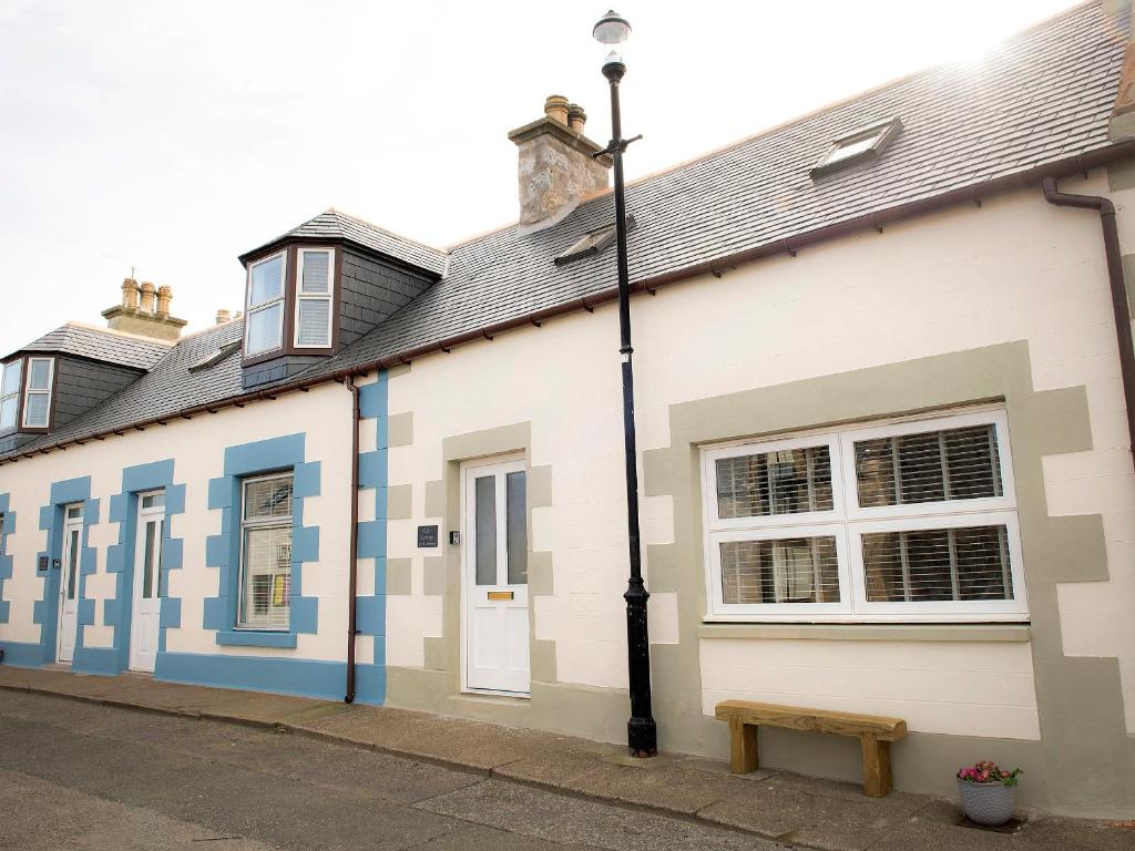 a building with blue and white paint on it at Eider Cottage in Buckie