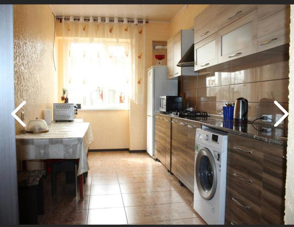 a kitchen with a washing machine in a kitchen at Adilet in Bishkek