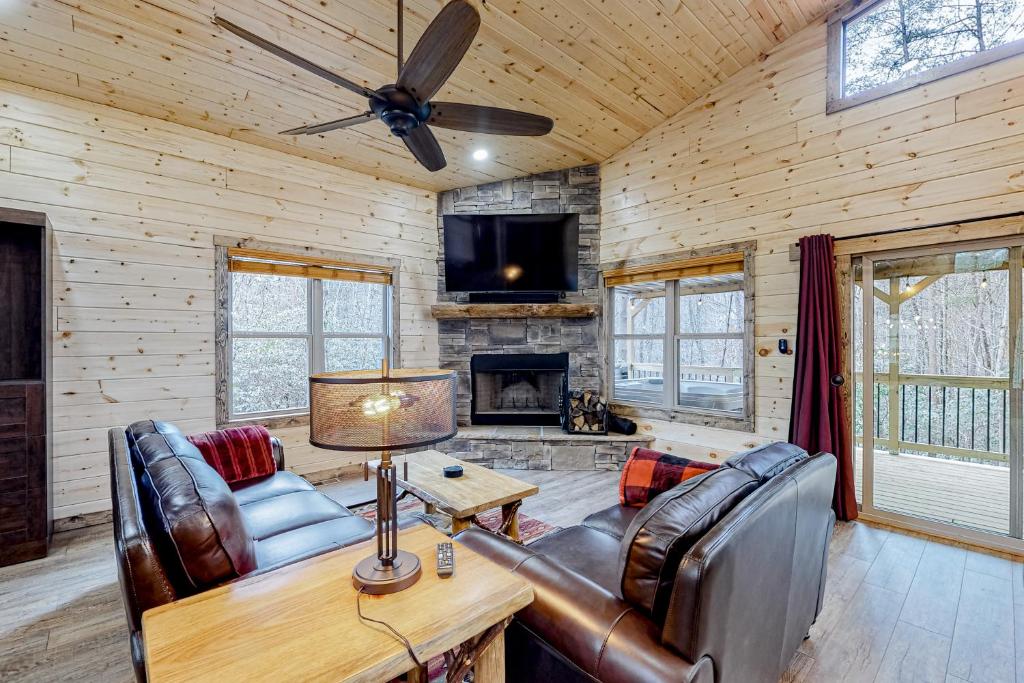 Sautee Nacoochee的住宿－Cozy Bear Cabin #1，客厅配有皮革家具和壁炉