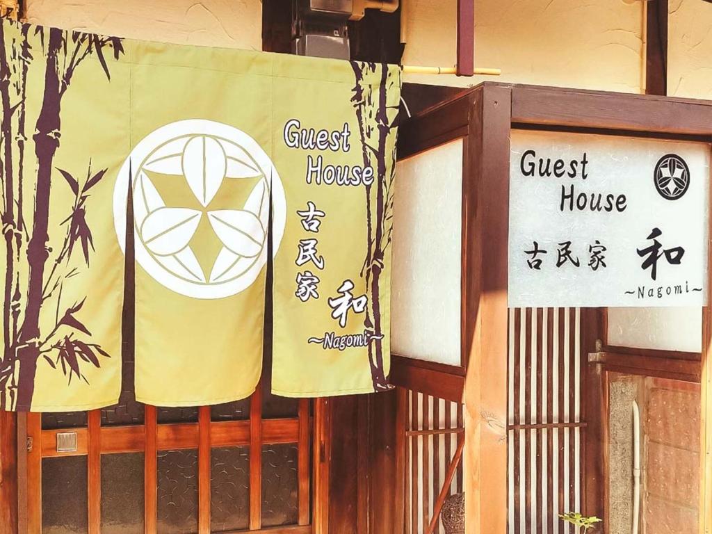 un cancello con le indicazioni per una struttura di Guest House Kominka Nagomi a Izumisano