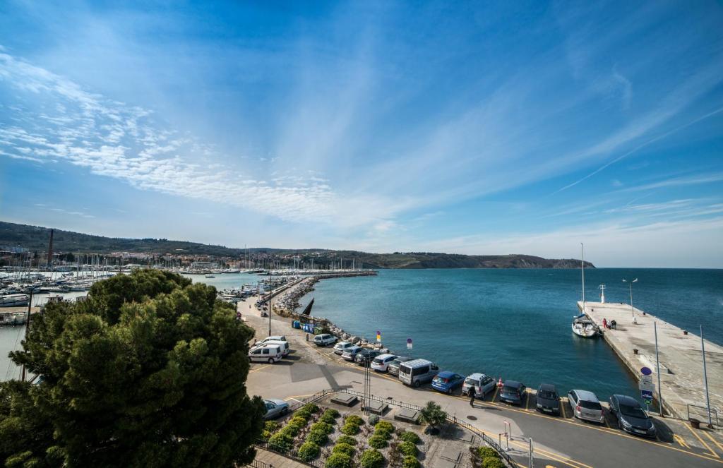 a view of a harbor with cars parked next to the water at Hotel Marina in Izola