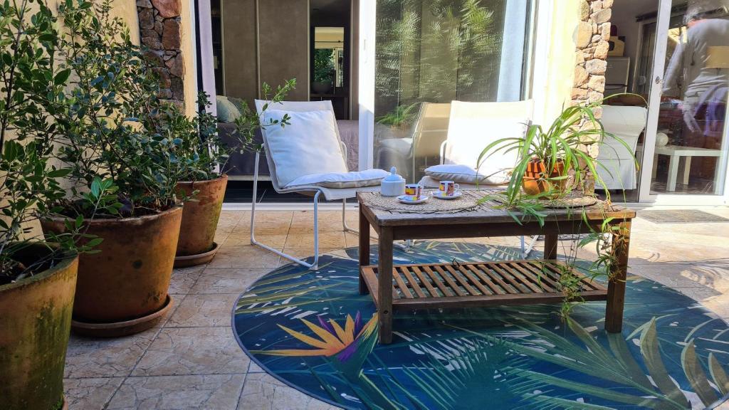 un patio avec une table, des chaises et des plantes dans l'établissement La Petite Villa 2 personnes, à Porto-Vecchio