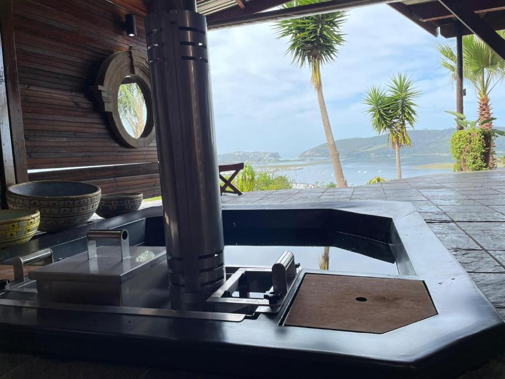 a kitchen sink with a view of the ocean at Knysna Lodge - Self Catering Unit with Woodfired Hot Tub in Knysna