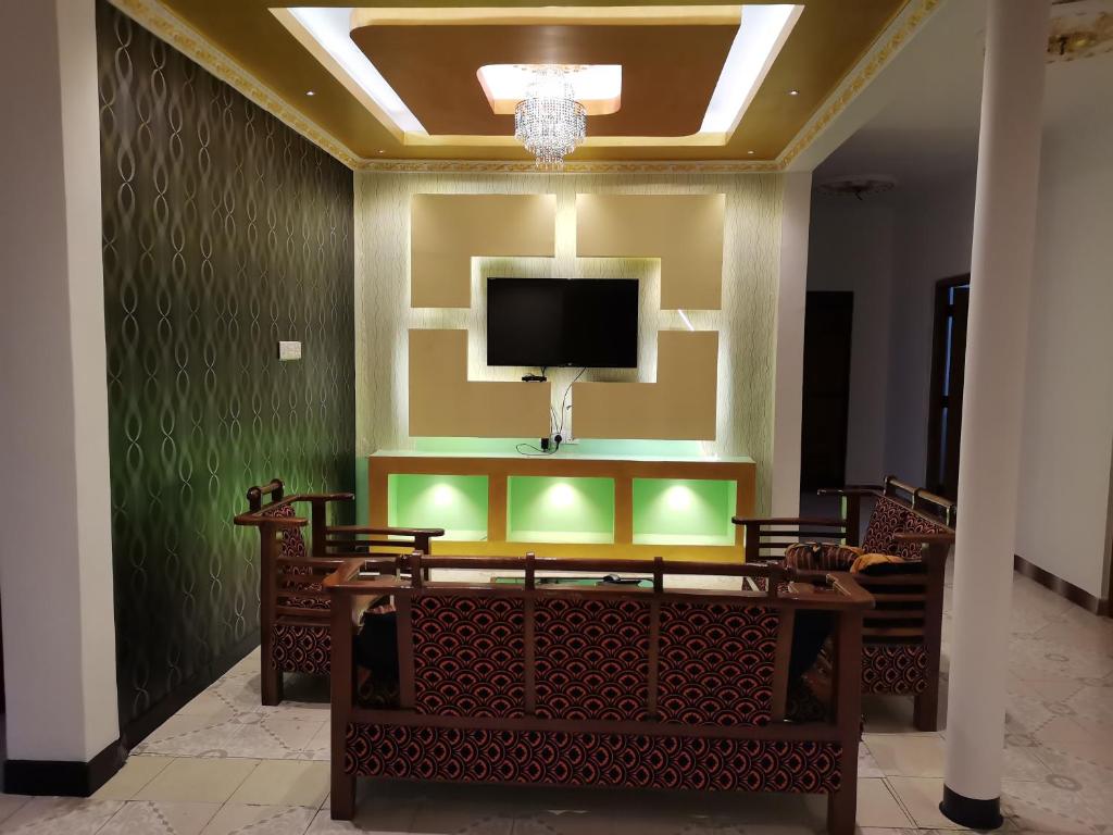 Nallur Holidays Inn في جافنا: غرفة مع تلفزيون على جدار مع طاولة