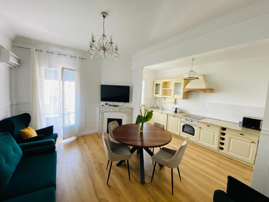 a kitchen and living room with a table and chairs at Le Nid Blanc Nice Centre in Nice