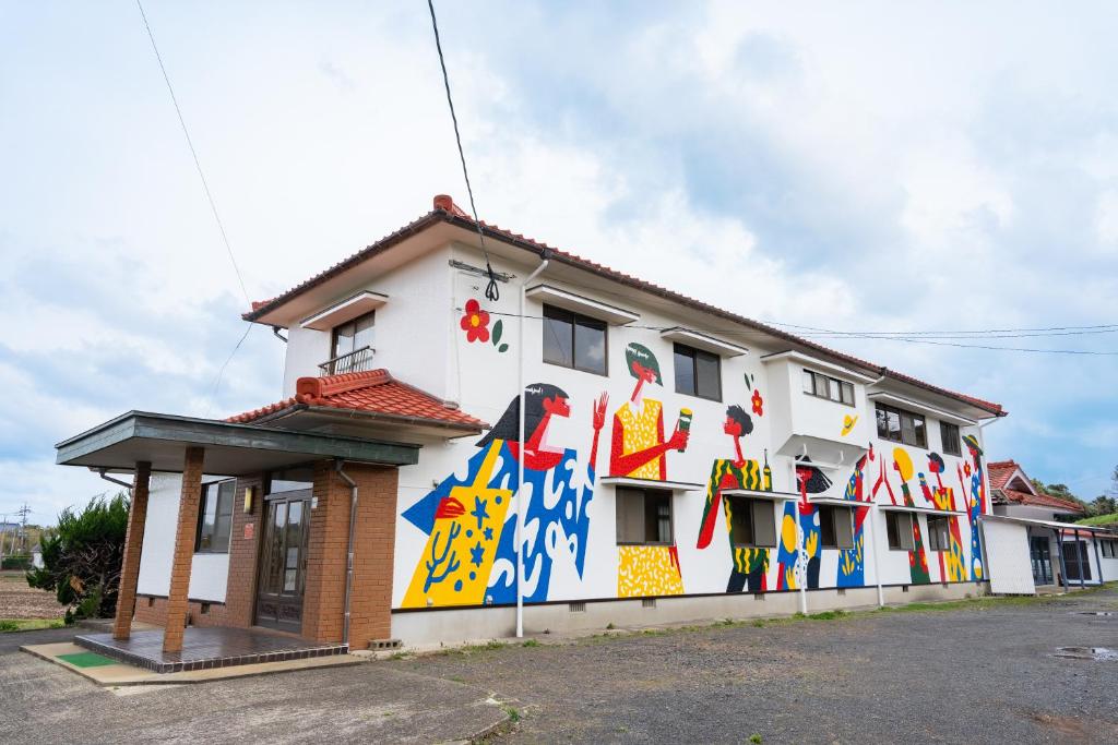 a building with a mural on the side of it at ikibase Guest House in Iki