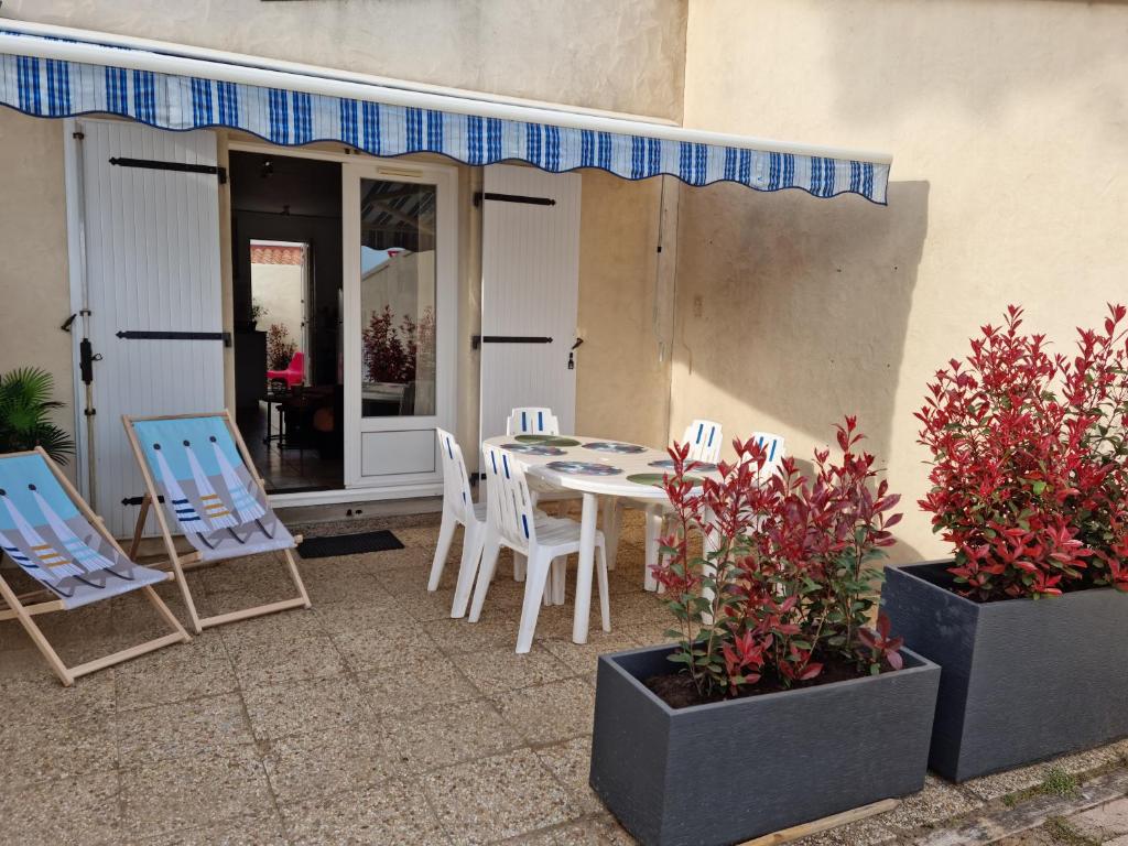 d'une terrasse avec des chaises, une table, une table et des chaises. dans l'établissement La commanderie, à La Tranche-sur-Mer