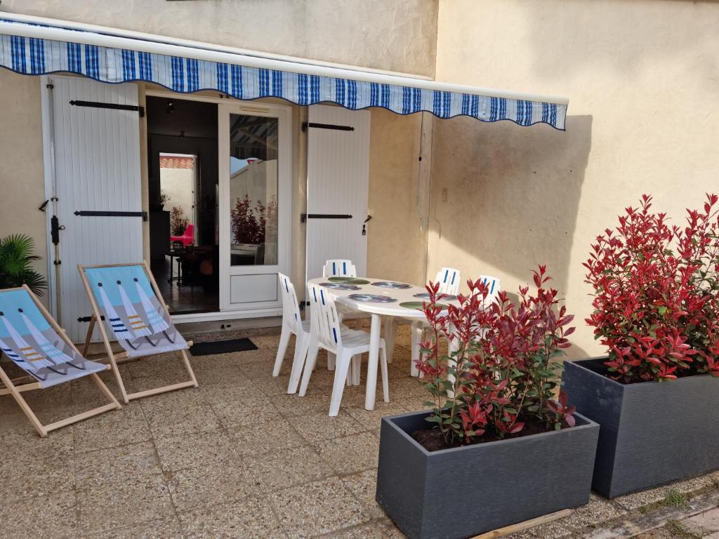 eine Terrasse mit Stühlen, einem Tisch und Stühlen in der Unterkunft La commanderie in La Tranche-sur-Mer
