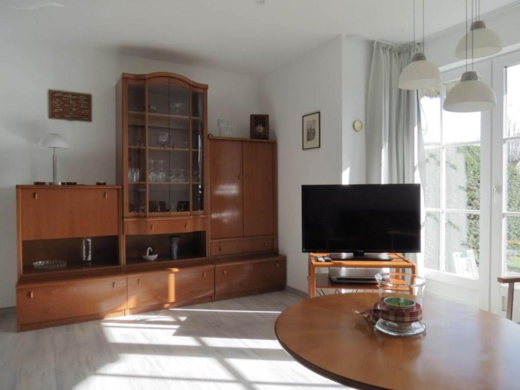 a living room with a tv and a wooden entertainment center at Hus op de Wurth Nr 7 in Büsumer Deichhausen