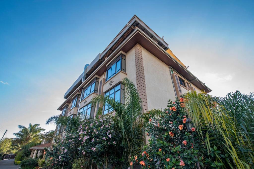 een gebouw met wat bloemen ervoor bij Fair Acres Boutique Hotel Karen in Nairobi