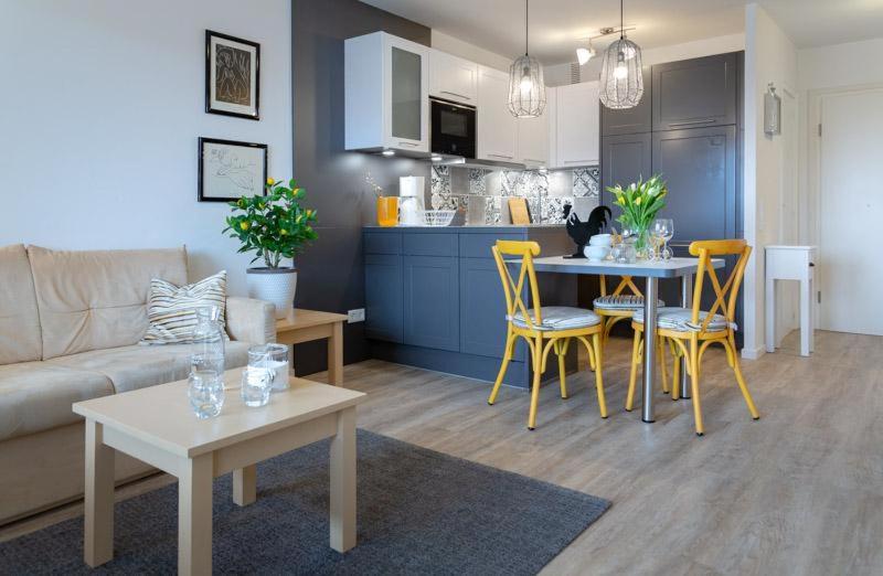 a living room with a couch and a table with chairs at Lemon Tree in Westerland