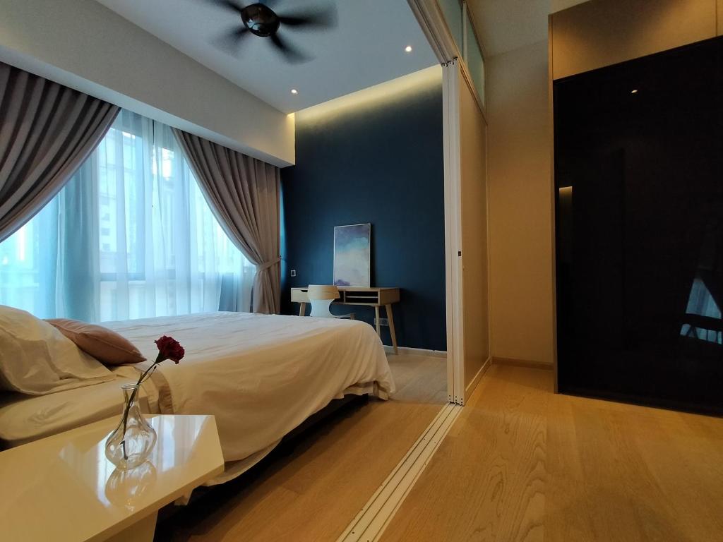 Un dormitorio con una cama y un jarrón con una flor en una mesa en Star Suite 5min Walk to KLCC Netflix, en Kuala Lumpur