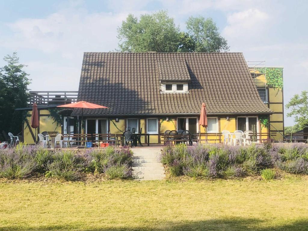 a yellow house with tables and chairs in front of it at Waldmaries Ferienhaus in Feldberg