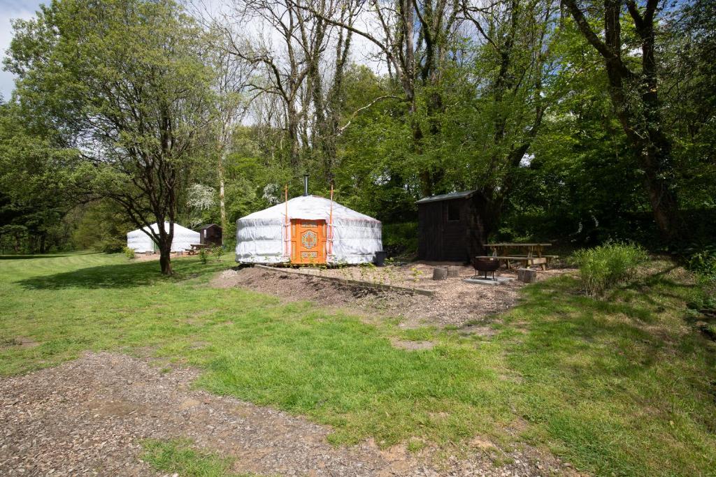 a yurt with an orange door in a field at Wellstone Yurts - Red Kite in Llanfyrnach