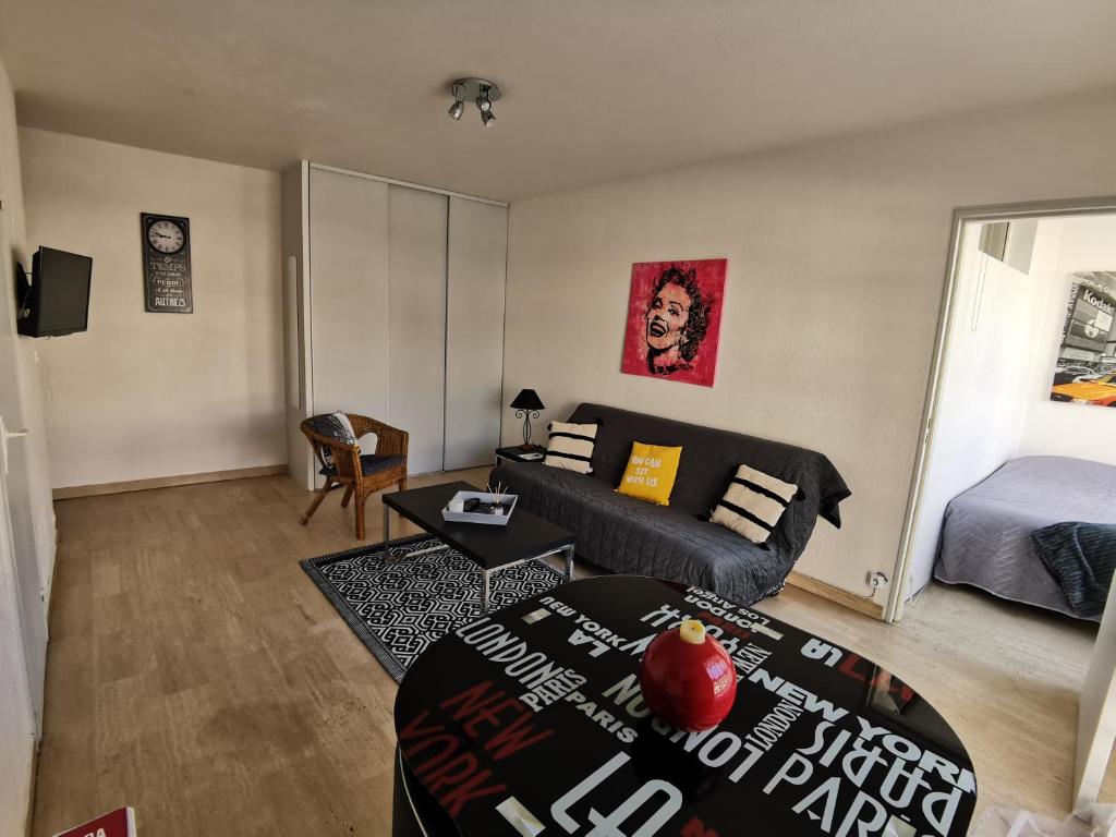 a living room with a couch and a bed at Grand studio de 33m² à 300m des plages in Vallauris