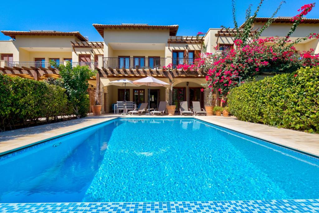 a swimming pool in front of a house at 2 bedroom Apartment Eros with private pool and garden, Aphrodite Hills Resort in Kouklia