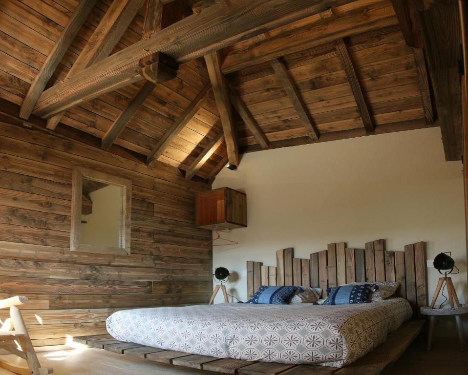 a bedroom with wooden walls and a large bed at Gîte de l&#39;Hôtel Dieu, en Bourgogne, avec SPA in La Bussière-sur-Ouche