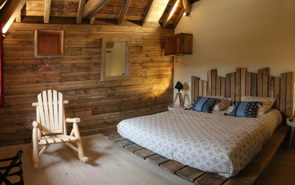 a bedroom with a bed and a wooden wall at Gîte de l&#39;Hôtel Dieu, en Bourgogne, avec SPA in La Bussière-sur-Ouche