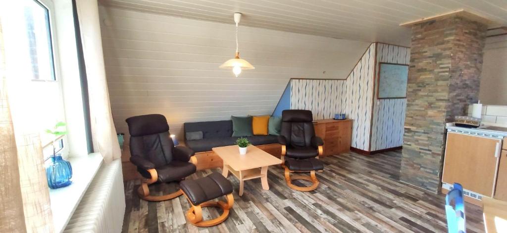 ein Wohnzimmer mit einem Sofa, Stühlen und einem Tisch in der Unterkunft Gästehaus Zur alten Post - Landhaus DG in Dornum